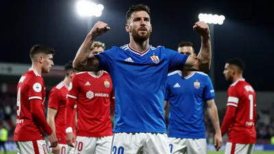 A photorealistic image of an anonymous Málaga CF player, aged 25-30, wearing a blue jersey and white shorts, with a red...