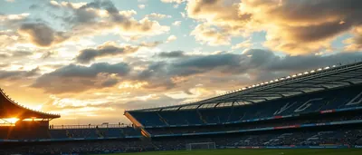 A dramatic evening match at Banús Football Center, two anonymous players mid-action: a blue-kit midfielder from Málaga...