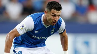 A photorealistic image of a Málaga CF player, wearing a blue jersey with white sleeves and white shorts, in a tight...