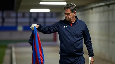 A 50-year-old Málaga CF coach, with a rugged, weathered complexion, stands in the dimly lit tunnel beneath Estadio La...